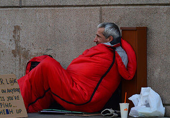 homeless man in red sleeping back