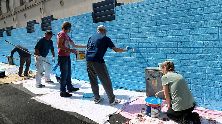COPE Galway Fairgreen Hostel residents painting the 'City of Tribes' mural.