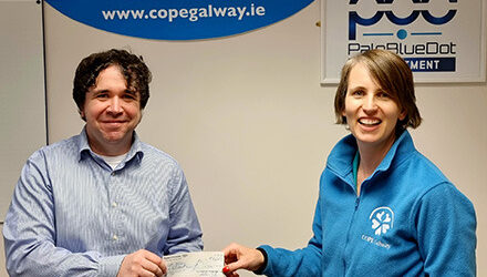 Pale Blue Dot director handing cheque Leonie of COPE Galway